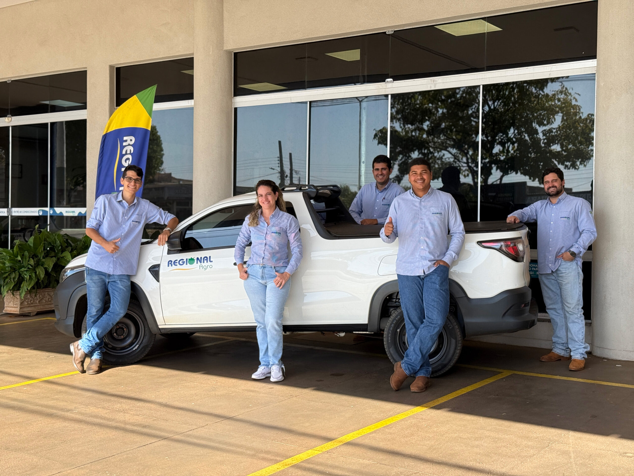 Time de pessoas colaboradoras Regional Agro, sorrindo ao lado do carro da empresa. Da esquerda para a direita: Gabriel Tosta, Rafaela, João Victor, Lucas e Gabriel Victor