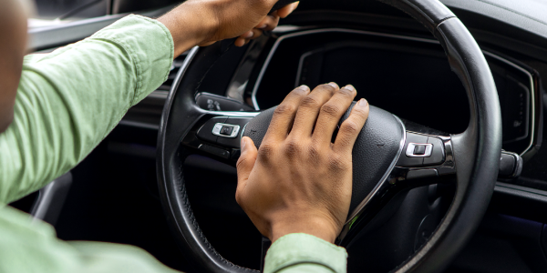 Motorista buzinando, demonstrando mau comportamento ao volante.