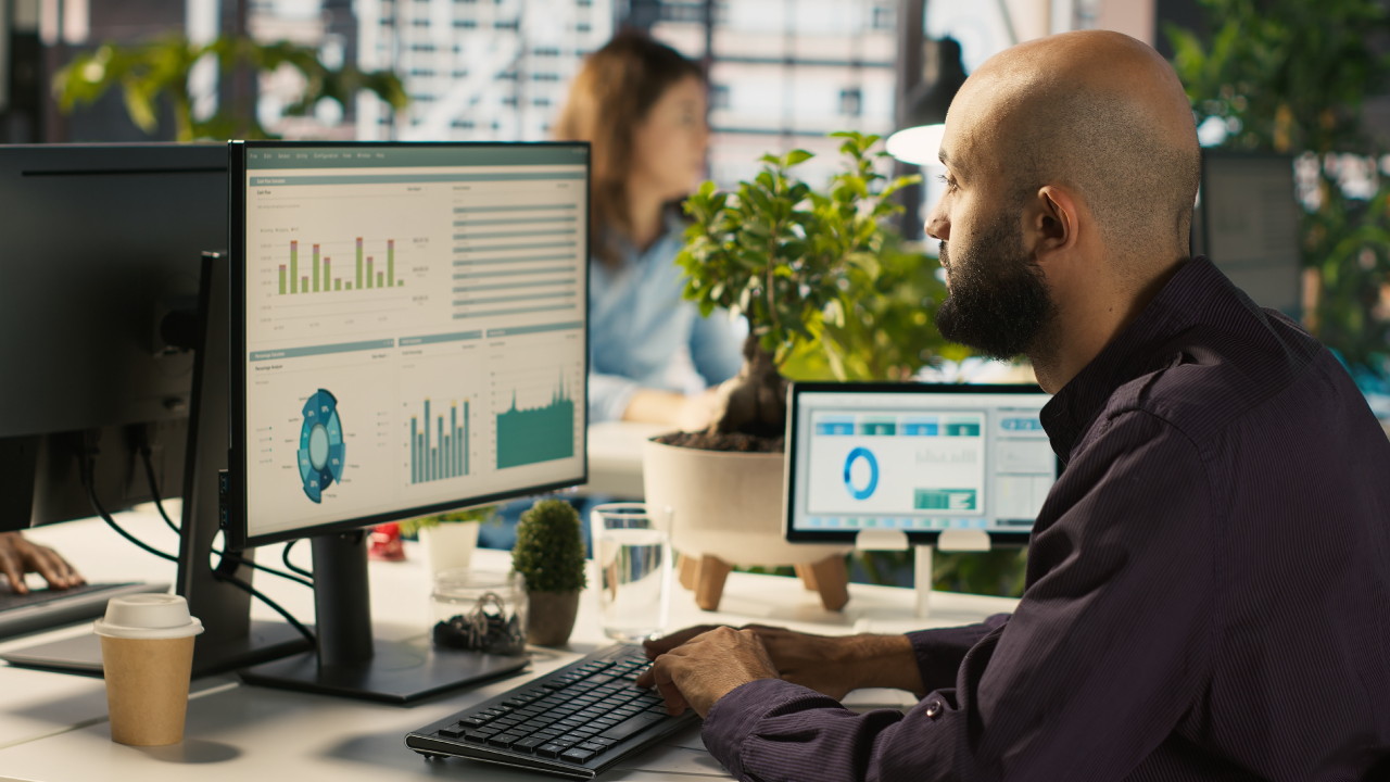 Gestor de frotas analisando relatórios de custos e desempenho de veículos em dashboard digital. 