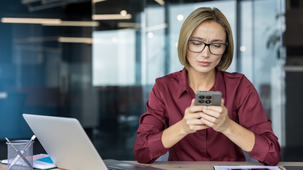 Gestora de frotas analisando documentos e números, com expressão de preocupação, antes de contar com dados de telemetria para apoiar a tomada de decisão.