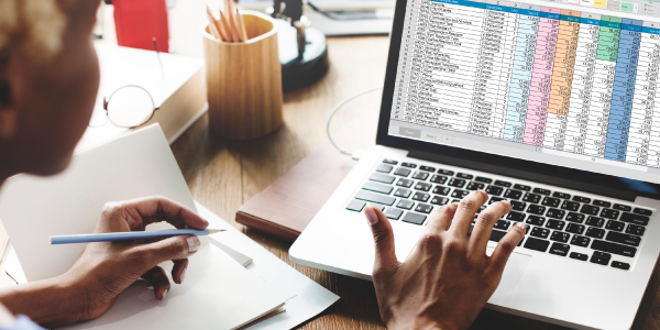 Gestor de frotas analisando planilhas e dados operacionais sobre CNH 2025/2026 e gestão de motoristas.